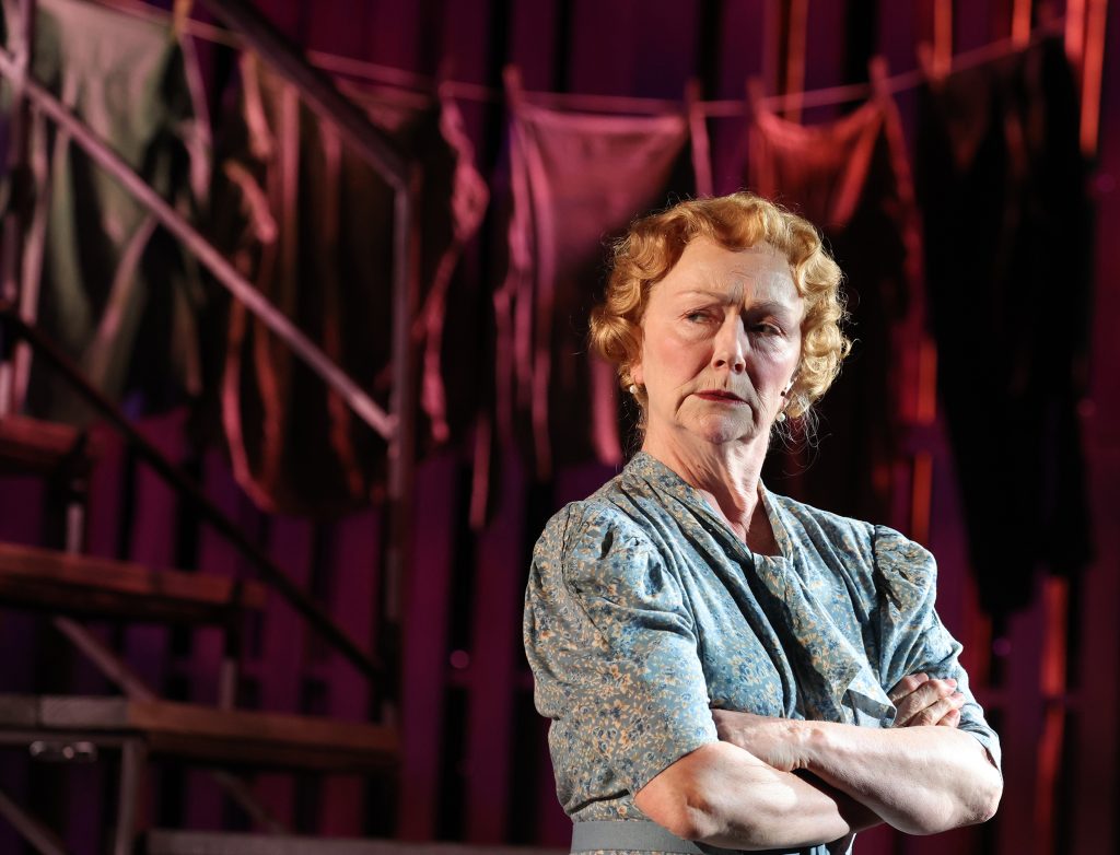 An actress standing with her arms crossed