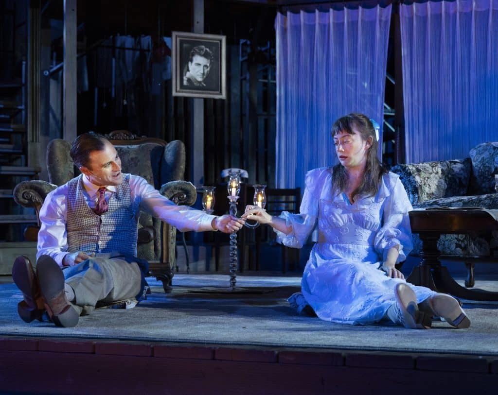 An actor hands a piece of gum to an actress